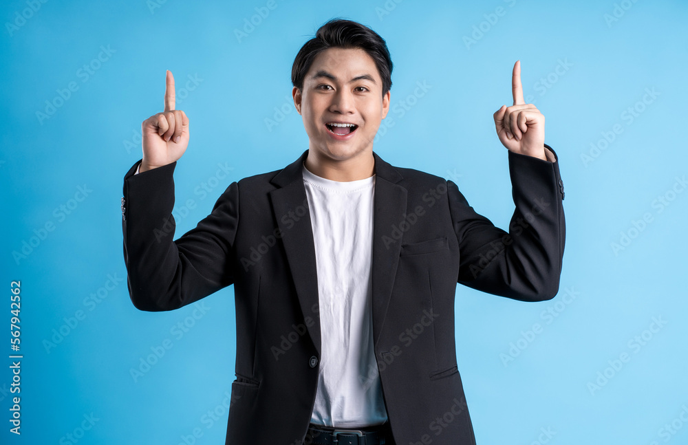 Young business man wearing a vest posing on a blue background