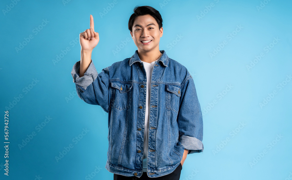 Fototapeta premium Young asian man posing on a blue background