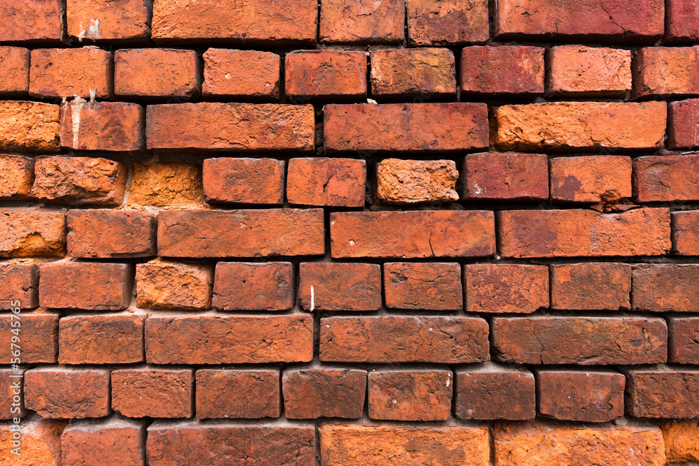 Bright red brick wall background. Red brick texture. Old Handmade brick. Brick wall with broken bricks Bright red brick wall background. Red brick texture. Old Handmade brick. Brick wall with broken bricks