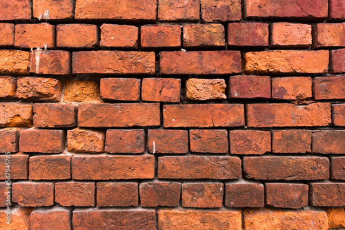 Bright red brick wall background. Red brick texture. Old Handmade brick. Brick wall with broken bricks