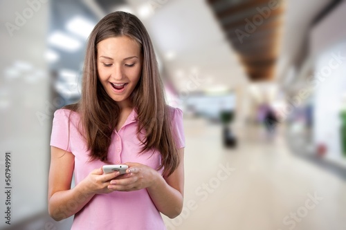 Happy young woman in casual clothes posing with phone