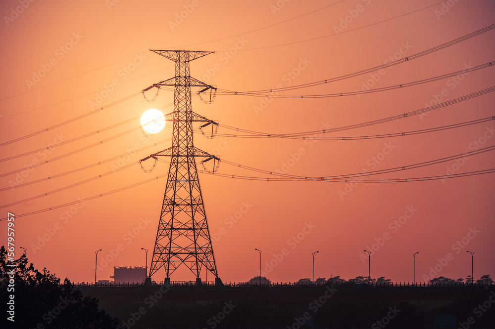 Fototapeta premium A view of a sunset full of power at twilight. High-voltage electric towers in the foreground. Marsonda Bridge, Tainan City, Taiwan