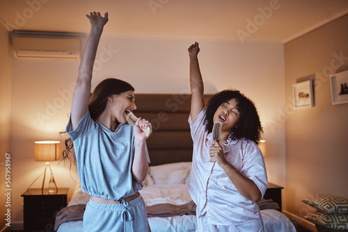 Friends, singing with brush and women in pajamas to get ready for girls night out dancing, fun music concert and happiness. Girl, friend and happy smile, girlfriends karaoke at sleepover in bedroom.