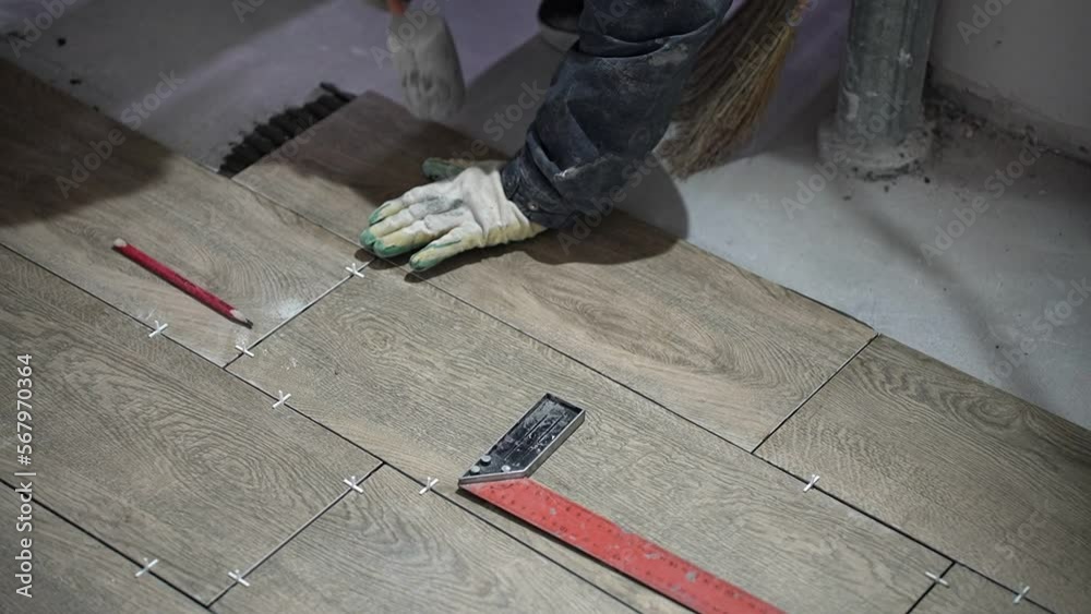 builder lays tiles in a new house under construction builder lays tiles in a new house under construction