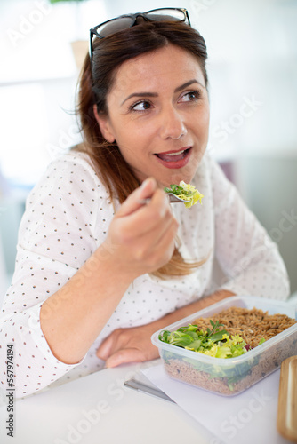 a happy woman eating salad