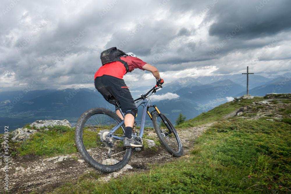 Rear view of mountain biker riding on uphill, Trentino-Alto Adige, Italy Rear view of mountain biker riding on uphill, Trentino-Alto Adige, Italy