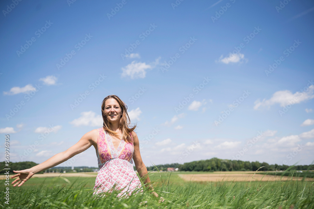 Happy woman enjoying with arms outstretched on meadow in the countryside, Bavaria, Germany Happy woman enjoying with arms outstretched on meadow in the countryside, Bavaria, Germany