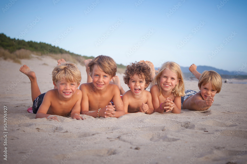 Portrait of group of kids lying down on the beach, Viana do Castelo, Norte Region, Portugal Portrait of group of kids lying down on the beach, Viana do Castelo, Norte Region, Portugal