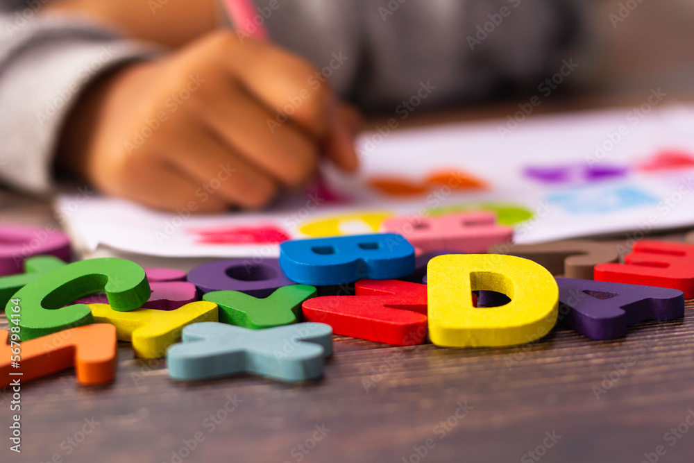 English alphabet made of square wooden tiles with the English alphabet scattered on hand. The concept of thinking development, grammar English alphabet made of square wooden tiles with the English alphabet scattered on hand. The concept of thinking development, grammar