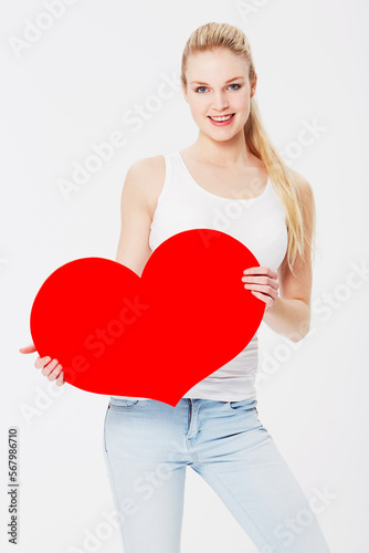 Valentines day, portrait and woman with a heart in a studio with a smile for a romantic gesture. Happiness, excited and female model from Australia holding a love shape isolated by a white background