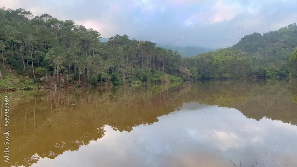 Lake surrounded by trees and a mountain in background Lake surrounded by trees and a mountain in background