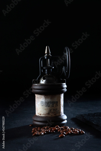 Antique wooden coffee grinder on a black background. Whole coffee beans .Vertical photo.