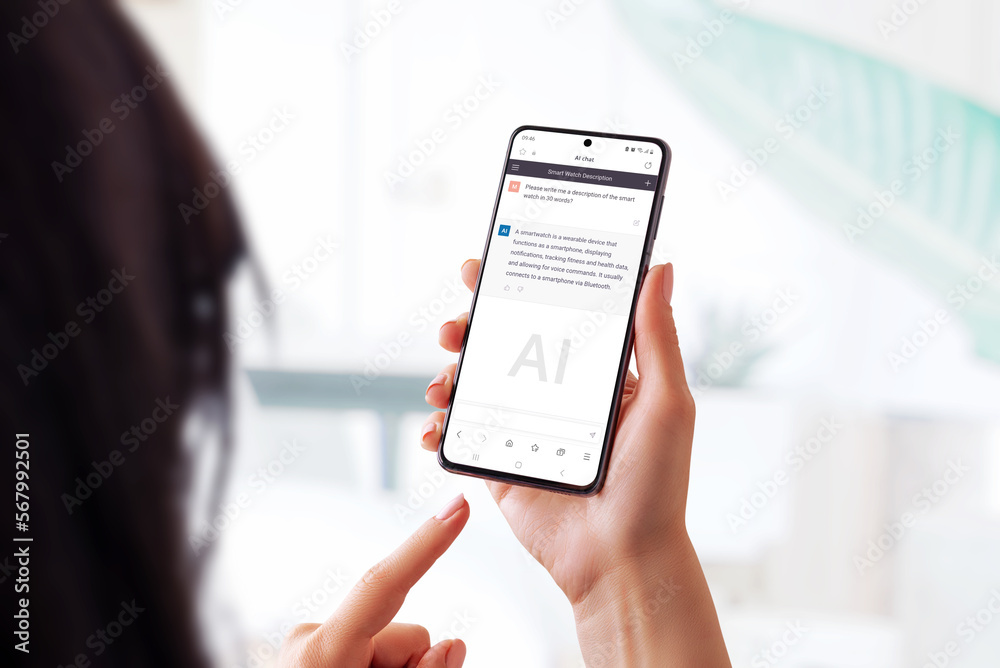 Woman holding a smart phone and using a chat bot app to ask questions ...