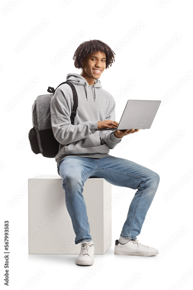 Male african american student sitting with a laptop computer and smiling at camera