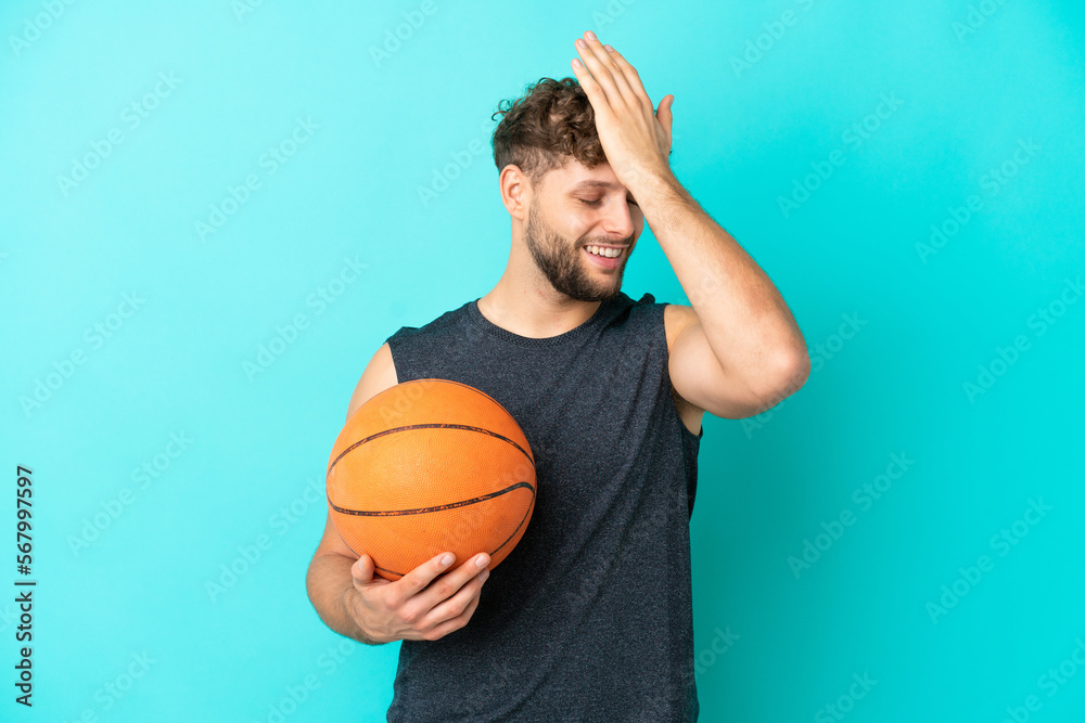 Handsome young man playing basketball isolated on blue background has realized something and intending the solution