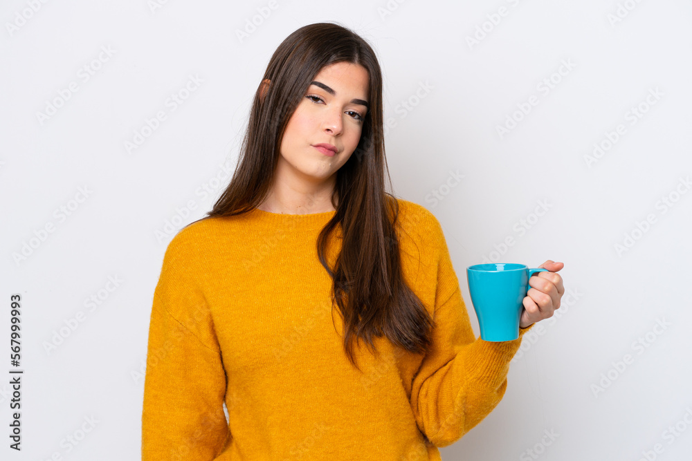 Young Brazilian woman holding cup of coffee isolated on white background with sad expression Young Brazilian woman holding cup of coffee isolated on white background with sad expression