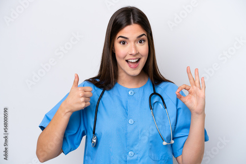 Young Brazilian nurse woman isolated on white background showing ok sign and thumb up gesture