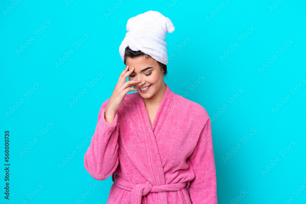 Young Brazilian woman with a bathrobe isolated on blue background laughing Young Brazilian woman with a bathrobe isolated on blue background laughing