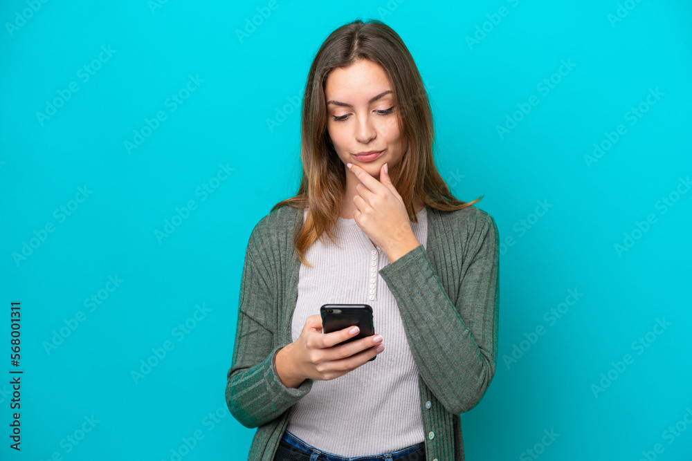 Young caucasian woman isolated on blue background thinking and sending a message Young caucasian woman isolated on blue background thinking and sending a message