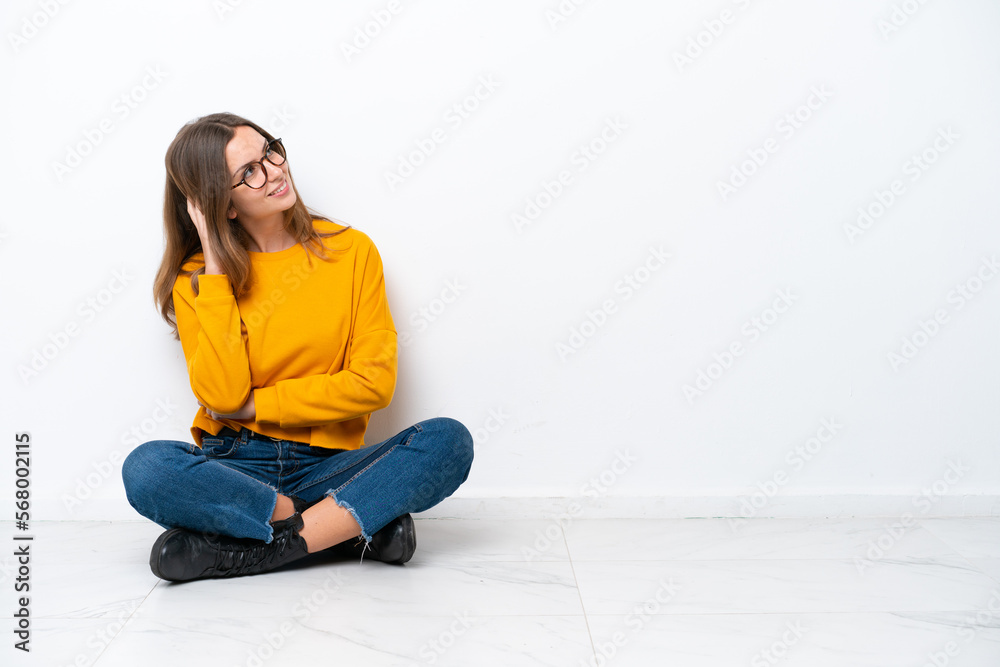 Young caucasian woman sitting on the floor isolated on white background thinking an idea Young caucasian woman sitting on the floor isolated on white background thinking an idea