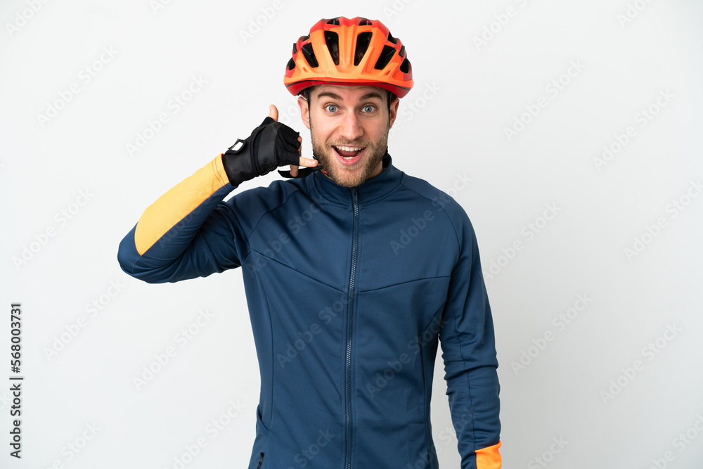 Young cyclist man isolated on white background making phone gesture. Call me back sign Young cyclist man isolated on white background making phone gesture. Call me back sign