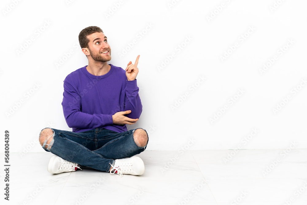 Young man sitting on the floor pointing up a great idea