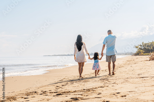 A family together walking on the beach.