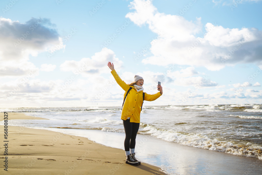 Woman travel blogger takes selfie for social networks by the sea at sunset. Travel, tourism, blogging, relax concept. Woman travel blogger takes selfie for social networks by the sea at sunset. Travel, tourism, blogging, relax concept.