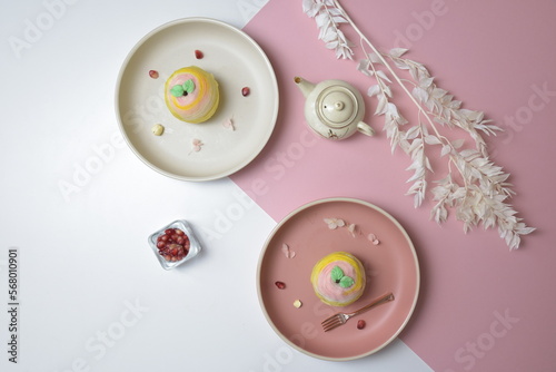 traditional Chinese vegetarian teochew crispy cute color pink and yellow yam mooncake on plate in white and pink color background photo