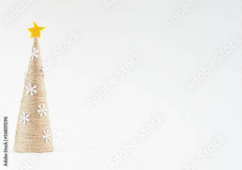 Homemade Christmas tree made of jute on a light background, place for an inscription