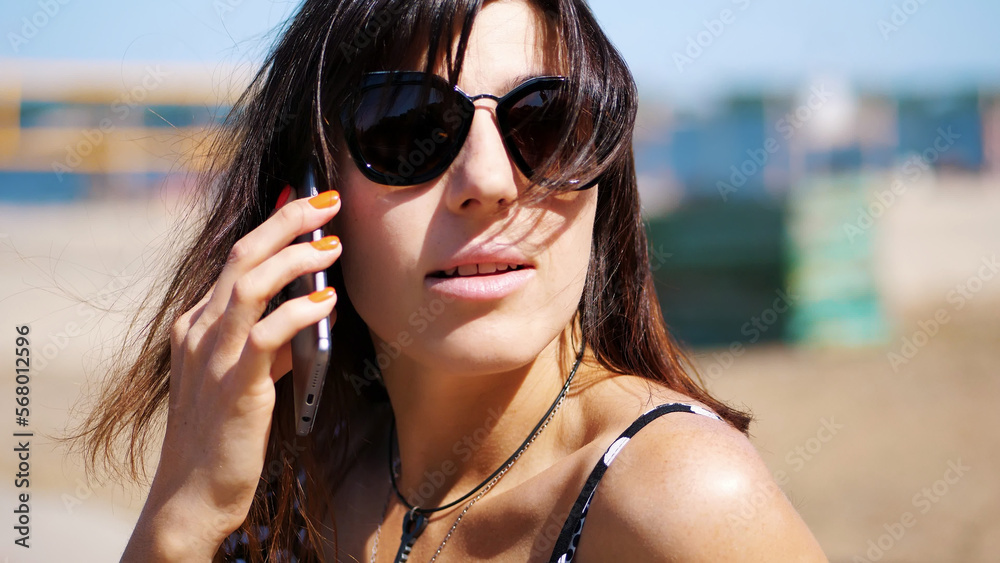 portrait, beautiful girl, woman in sun glasses talking on a mobile phone. on the beach, on a hot summer day, portrait, beautiful girl, woman in sun glasses talking on a mobile phone. on the beach, on a hot summer day,
