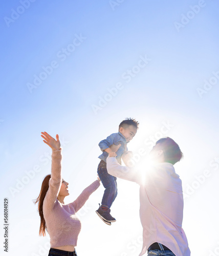 Happy Asian family  standing and playing with child