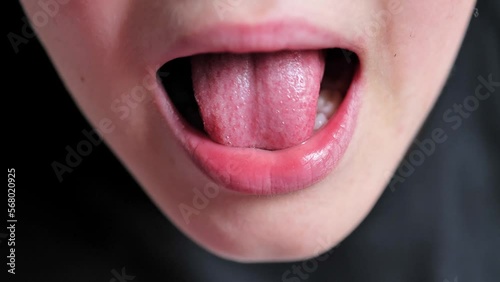 boy touches a crooked milk tooth. Kid lost a tooth. Close up of tooth that falls macro