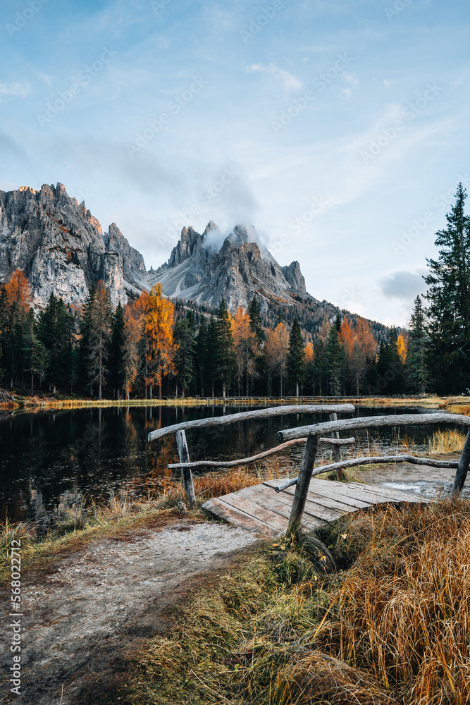 Autumn colours of Lake Lago d'Antorno and bridge in Dolomites Italy
