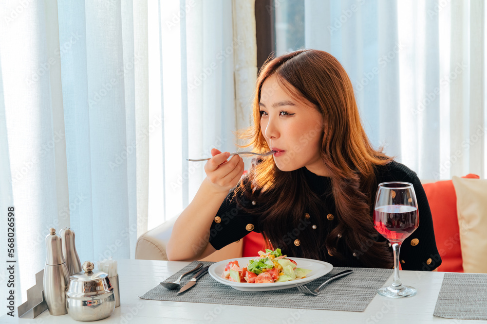 Closeup of asian woman eating fresh vegetable salad Closeup of asian woman eating fresh vegetable salad