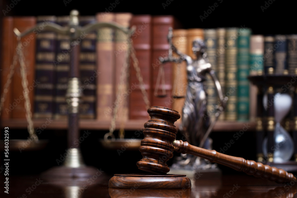 Lawyer office. Judge’s gavel, Themis sculpture and legal books in the bookshelf. Lawyer office. Judge’s gavel, Themis sculpture and legal books in the bookshelf.