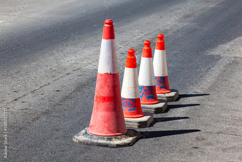 Traffic cones stand in a row on an asphalt road. Devices for temporary marking of roads. Avriynye cones stand on the road. photo