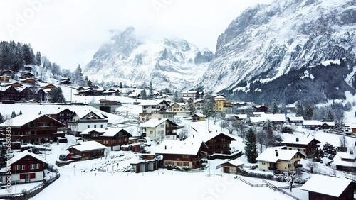 Grindelwald village in Switzerland aerial drone video on snowy day in winter time