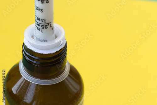 Close-Up of Antibiotic Syringes in Brown Bottle on yellow background. Recovering from infection. photo