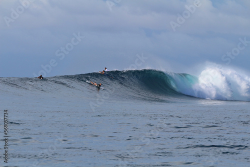 Photography Surfers jockey for position as they try to catch a wave in the ocean while surfi