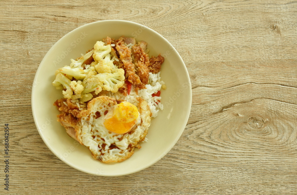 stir fried cauliflower with crispy chicken and egg topping plain rice on plate stir fried cauliflower with crispy chicken and egg topping plain rice on plate