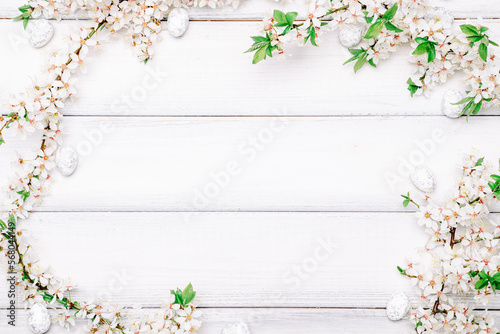 Easter eggs background. May flowers, white happy easter egg on wooden spring background. Easter card. Flat lay.