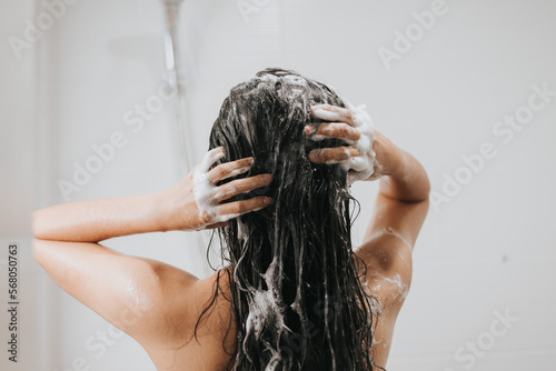 Woman washing hair with shampoo and shower in bathroom, Asian female body and hair care with foam to freshness. Spa and Health care. photo