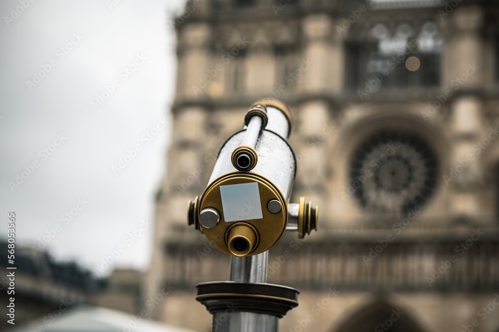 Telescope. City spyglass. Telescope overlooking Notre Dame. View point with telescope on the Notre Dame.
