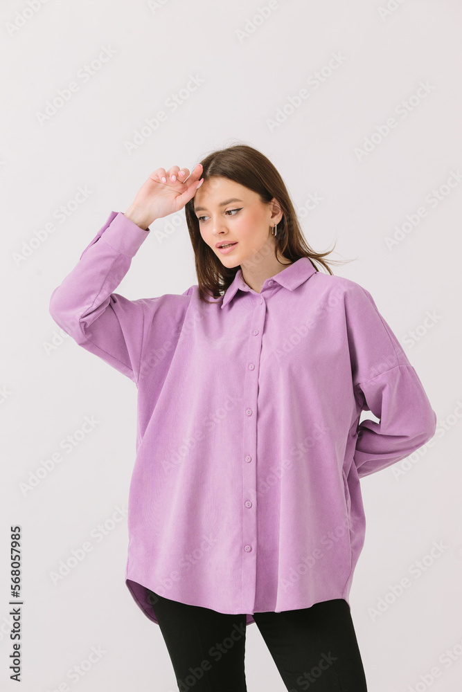Photo of a beautiful brunette woman in a colored purple shirt isolated on a white background. Shirt mockup. Photo of a beautiful brunette woman in a colored purple shirt isolated on a white background. Shirt mockup.