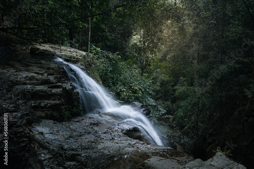Blurred waterfall stream falls down steep mountain and disappears into deep gorge, Samui, Thailand