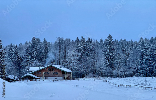 Berghütte (Frasdorfer Hütte) an einem trüben Winterabend in verschneiter Landschaft am Waldrand im Hochries Gebiet, Alpen, Chiemgau, Bayern, Deutschland © Michael Thaler