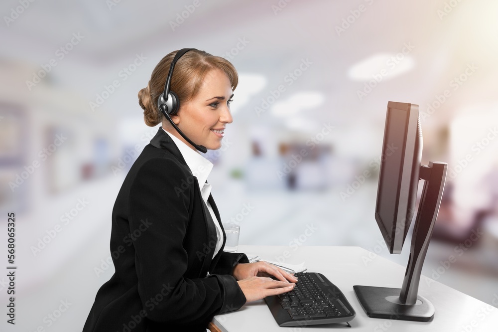 Young woman sitting and working on computer in modern office. Young woman sitting and working on computer in modern office.