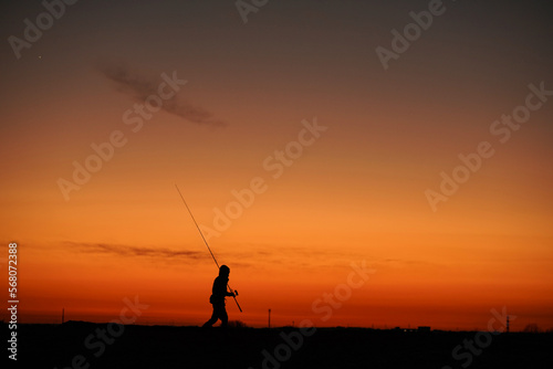  釣竿を持って歩く男性 © yamasan