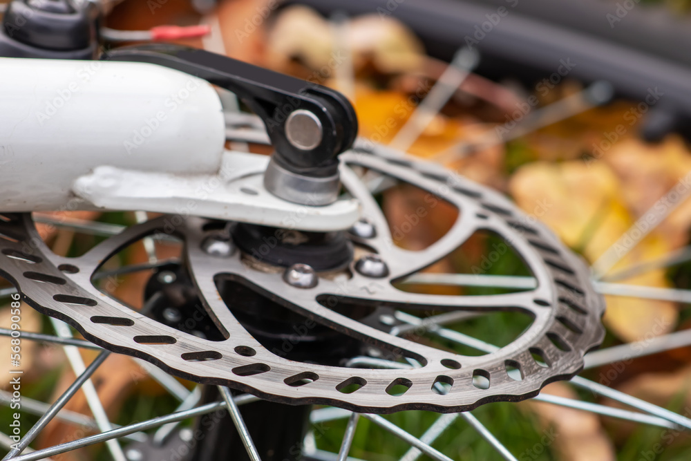 Bicycle disk brake rotor in focus. Metal details of transport concept Bicycle disk brake rotor in focus. Metal details of transport concept
